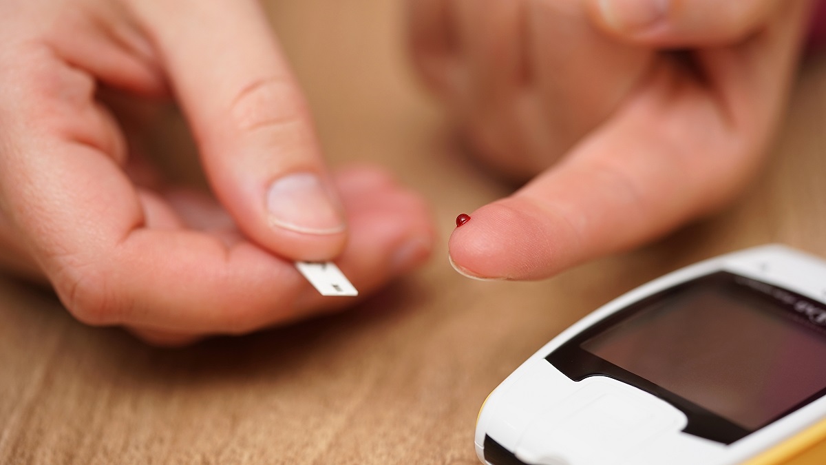 closeup of female finger with blood drop and test stripe, concept of illness, diabetes, high glycemic level in blood